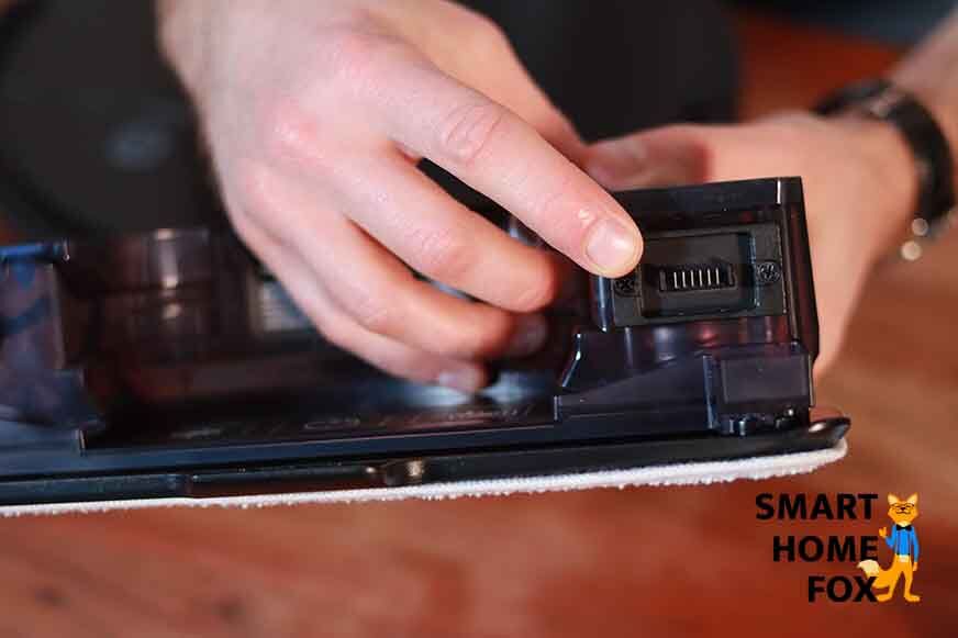 Ein Finger zeigt auf die elektrischen Kontakte am Wassertank des Ecovacs Deebot T9 AIVI